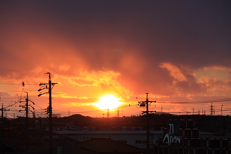 小雪舞う中の燃えるたぎる夕陽
